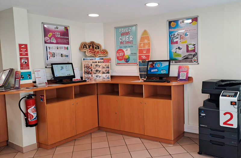 Intérieur du copie service ARIA Repro à Fontainebleau avec ordinateurs en libre-service et photocopieur